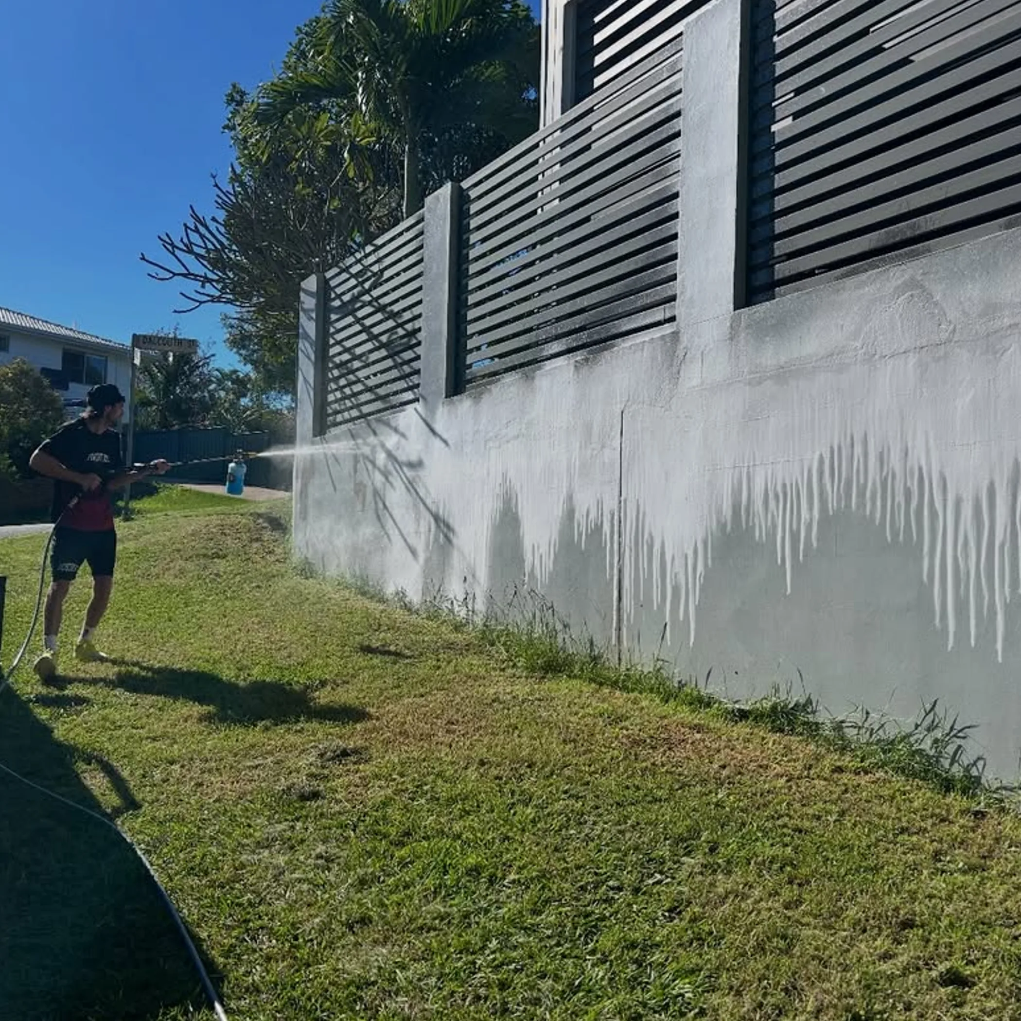 person pressure washing outdoor surface